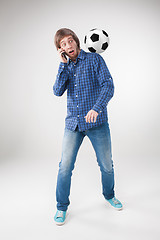Image showing The portrait of fan with ball, holding phone on white background