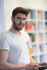 Image showing student in school library using tablet for research