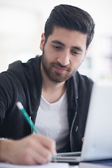 Image showing student in school library using laptop for research