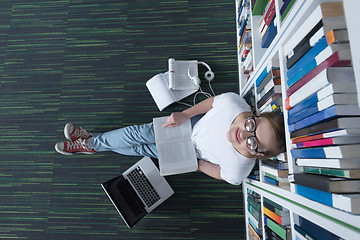 Image showing female student study in library, using tablet and searching for 