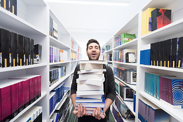 Image showing Student holding lot of books in school library