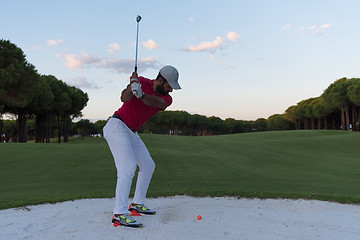 Image showing golfer hitting a sand bunker shot on sunset