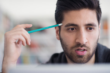 Image showing student in school library using laptop for research