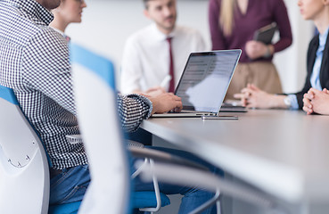 Image showing close up of business man hands typing on laptop with team on mee