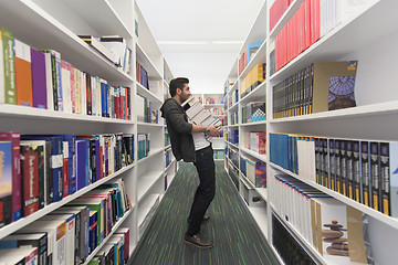 Image showing Student holding lot of books in school library