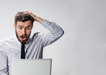 Image showing The young surprised man with his laptop computer