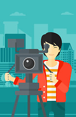 Image showing Cameraman with movie camera on a tripod.