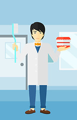 Image showing Dentist with dental jaw model and toothbrush.