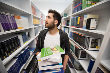 Image showing Student holding lot of books in school library