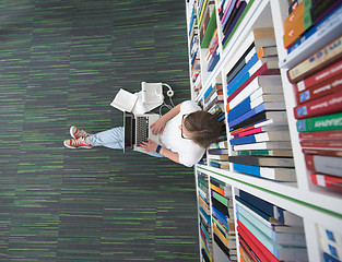 Image showing female student study in library, using tablet and searching for 