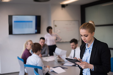 Image showing business woman working on tablet at meeting room