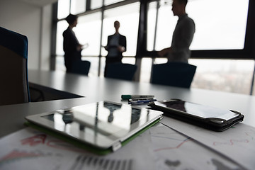 Image showing close up of tablet, business people on meeting in background