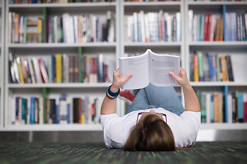 Image showing female student study in library, using tablet and searching for 