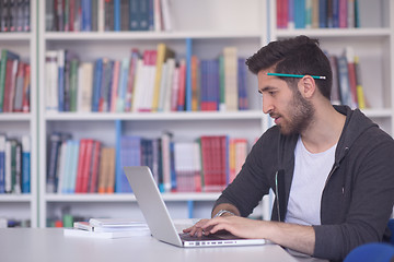 Image showing student in school library using laptop for research
