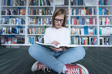 Image showing female student study in library, using tablet and searching for 