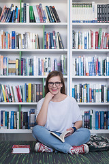 Image showing famale student reading book in library