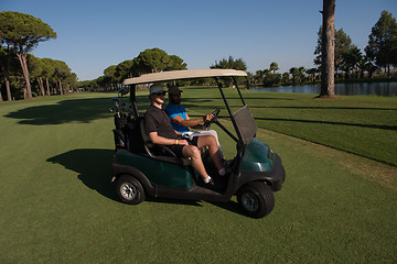 Image showing golf players driving cart at course