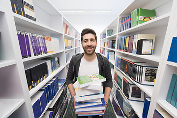 Image showing Student holding lot of books in school library