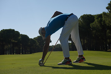 Image showing golf player placing ball on tee