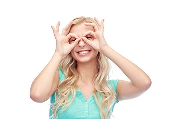 Image showing young woman looking through finger glasses