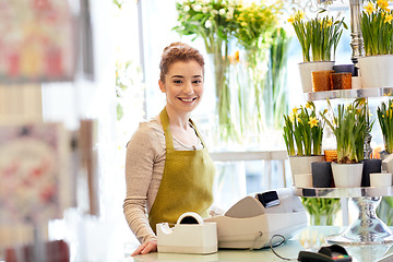 Image showing smiling florist woman at flower shop cashbox