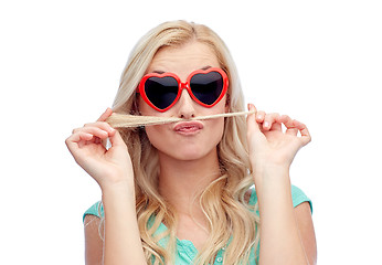 Image showing happy young woman making mustache with her hair