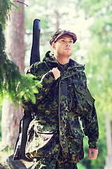 Image showing young soldier or hunter with gun in forest