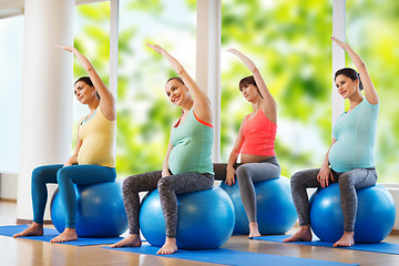 Image showing happy pregnant women exercising on fitball in gym