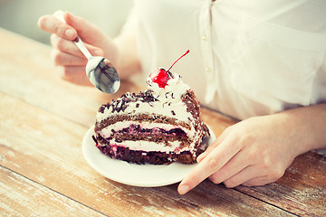 Image showing close up of woman eating chocolate cherry cake