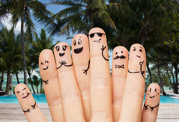 Image showing close up of fingers with smiley faces on beach