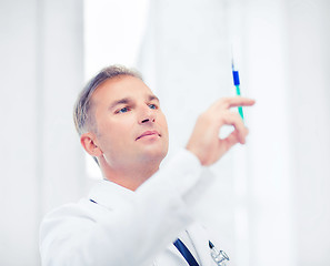 Image showing male doctor holding syringe with injection