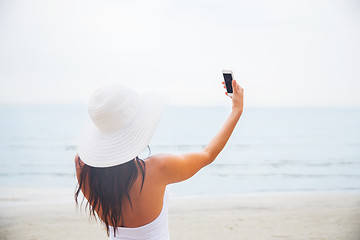 Image showing smiling young woman taking selfie with smartphone