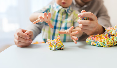 Image showing father and son playing with ball clay at home