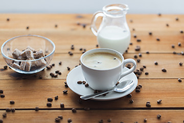 Image showing close up coffee cup and grains on wooden table