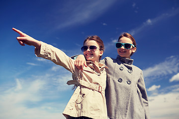 Image showing happy little girls hugging and pointing finger