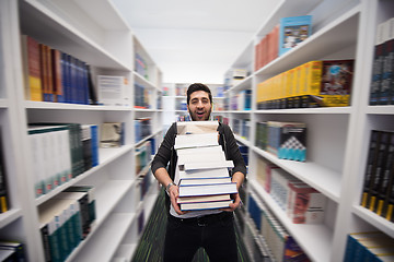 Image showing Student holding lot of books in school library