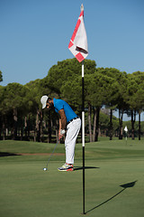 Image showing golf player hitting shot at sunny day