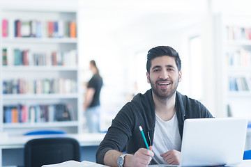 Image showing student in school library using laptop for research