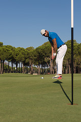 Image showing golf player hitting shot at sunny day