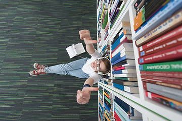 Image showing female student study in library, using tablet and searching for 