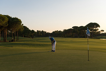 Image showing golfer hitting ball to hole