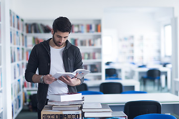 Image showing portrait of student while reading book  in school library