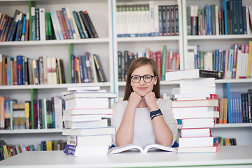 Image showing female student study in library, using tablet and searching for 