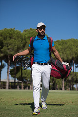 Image showing golf player walking and carrying bag