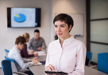 Image showing hispanic businesswoman with tablet at meeting room