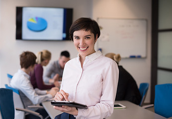Image showing hispanic businesswoman with tablet at meeting room