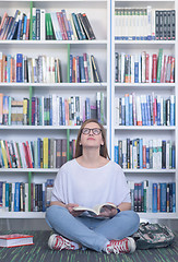 Image showing famale student reading book in library