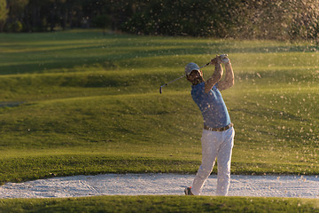 Image showing golfer hitting a sand bunker shot on sunset