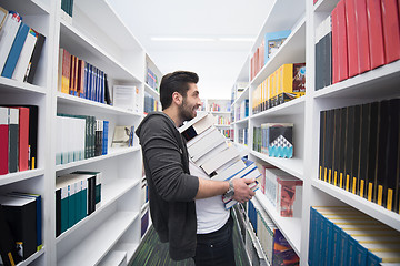 Image showing Student holding lot of books in school library