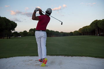 Image showing golfer hitting a sand bunker shot on sunset